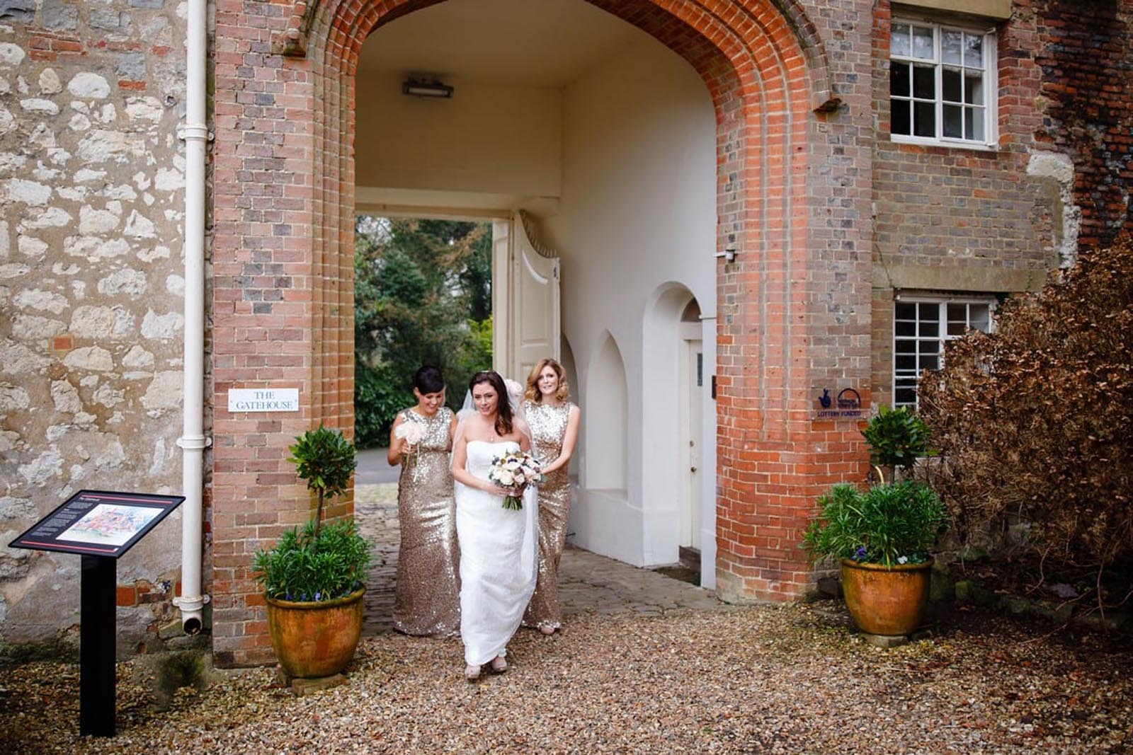 Bridal party walking through the grounds of Farnham castle